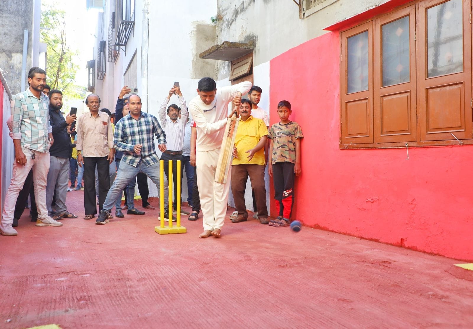 Dirty back lane becomes,activity, Mayor plays cricket,residents